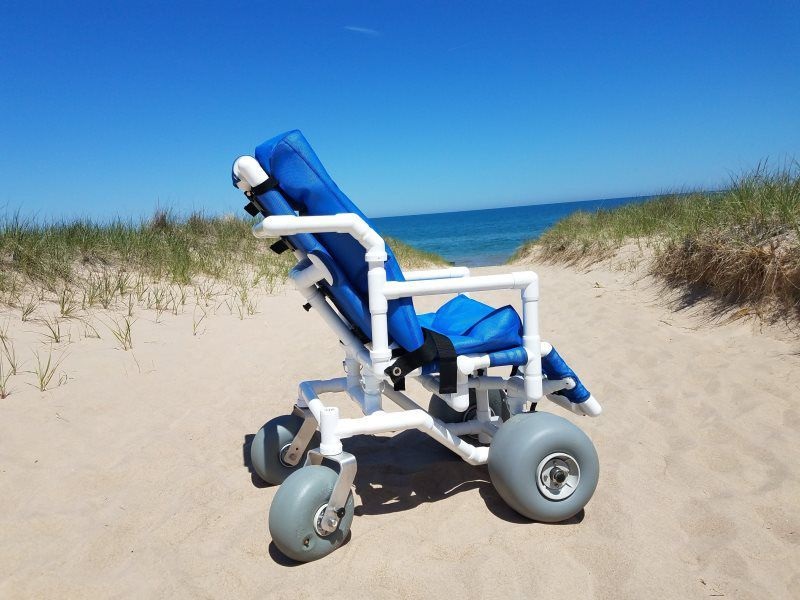 A beach wheelchair with the sea in the background.