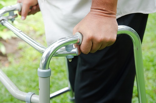 Closeup of the hands of a man using a walker.