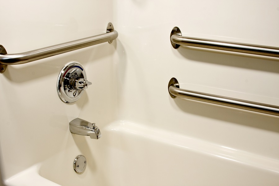 A close-up image of three grab bars in a white bathtub.