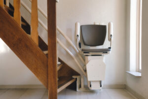 A mobility lift that transports a person up a residential staircase