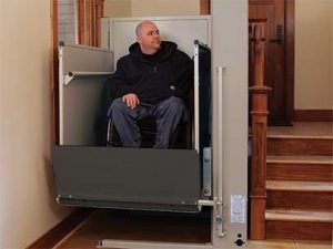 A man using a wheelchair lift in his home.