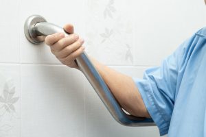 Woman using a grab bar in a bathroom for mobility support
