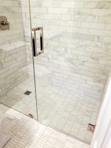 Walk-in shower with tan tile and a glass door