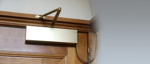 Automatic interior door opener installed on top corner of a wooden door